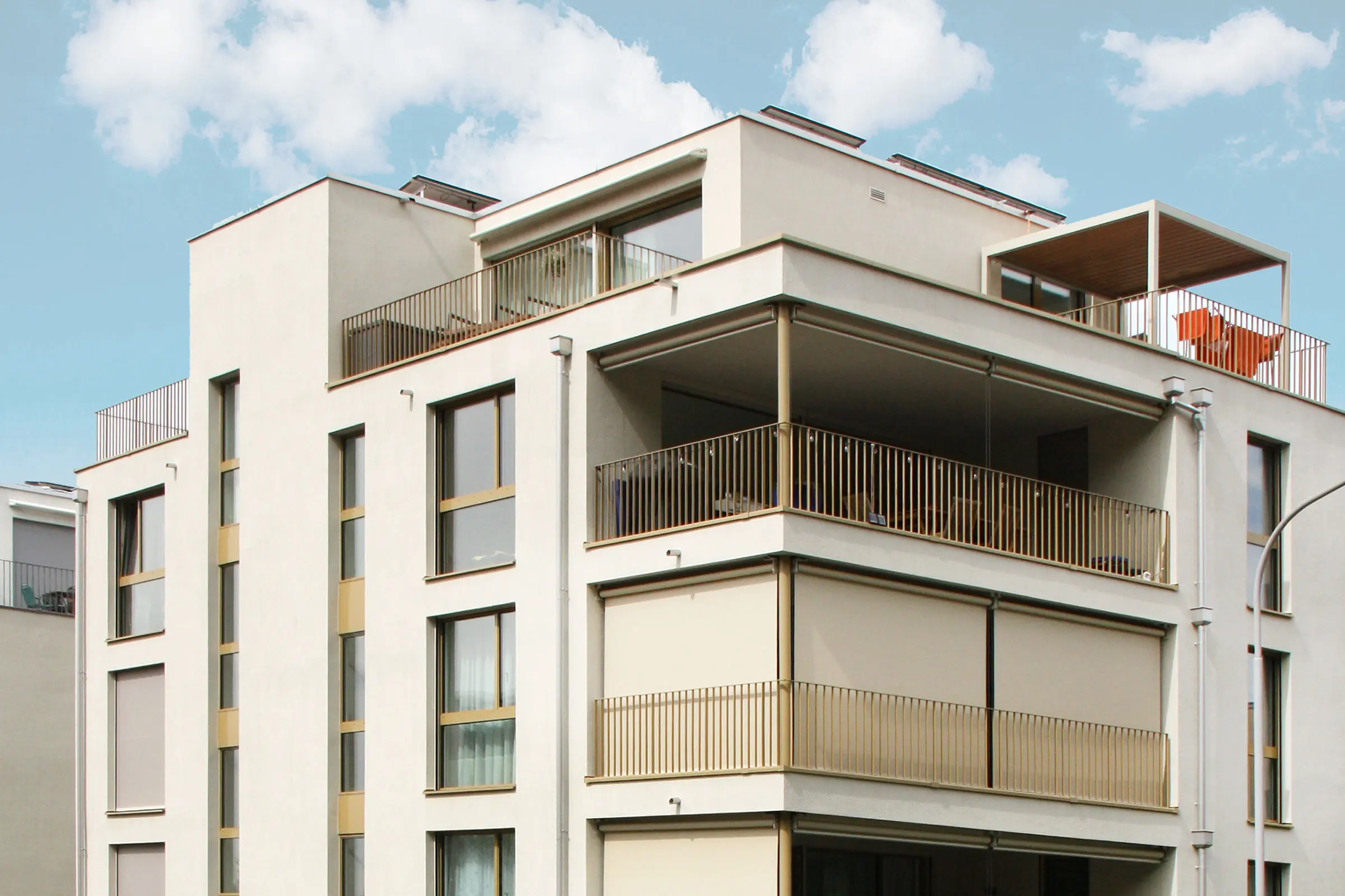 Mehrfamilienhaus mit heller Fassade und einem Fassadenbegrünungssystem