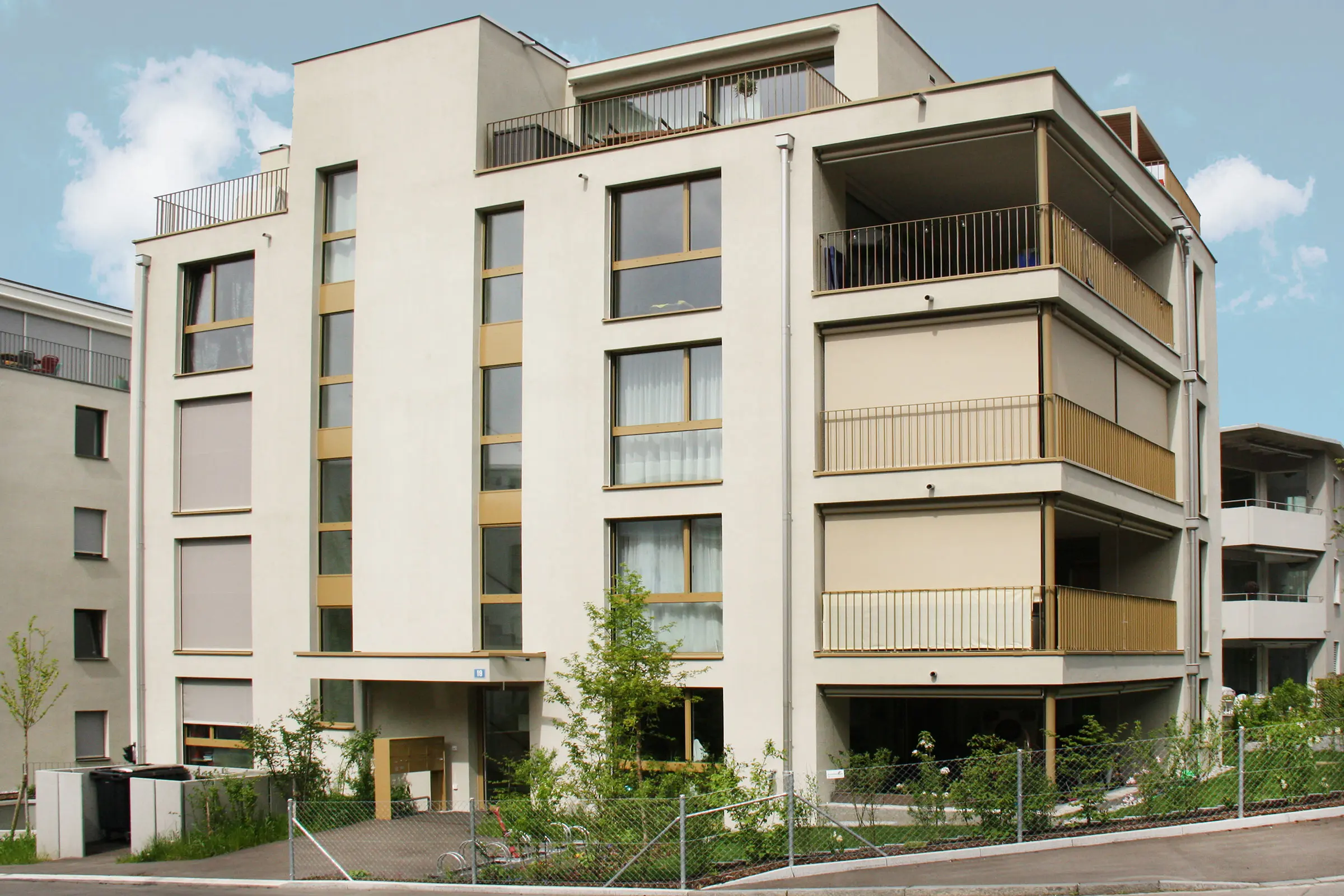 Mehrfamilienhaus mit heller Fassade in Creme einem Fassadenbegrünungssystem