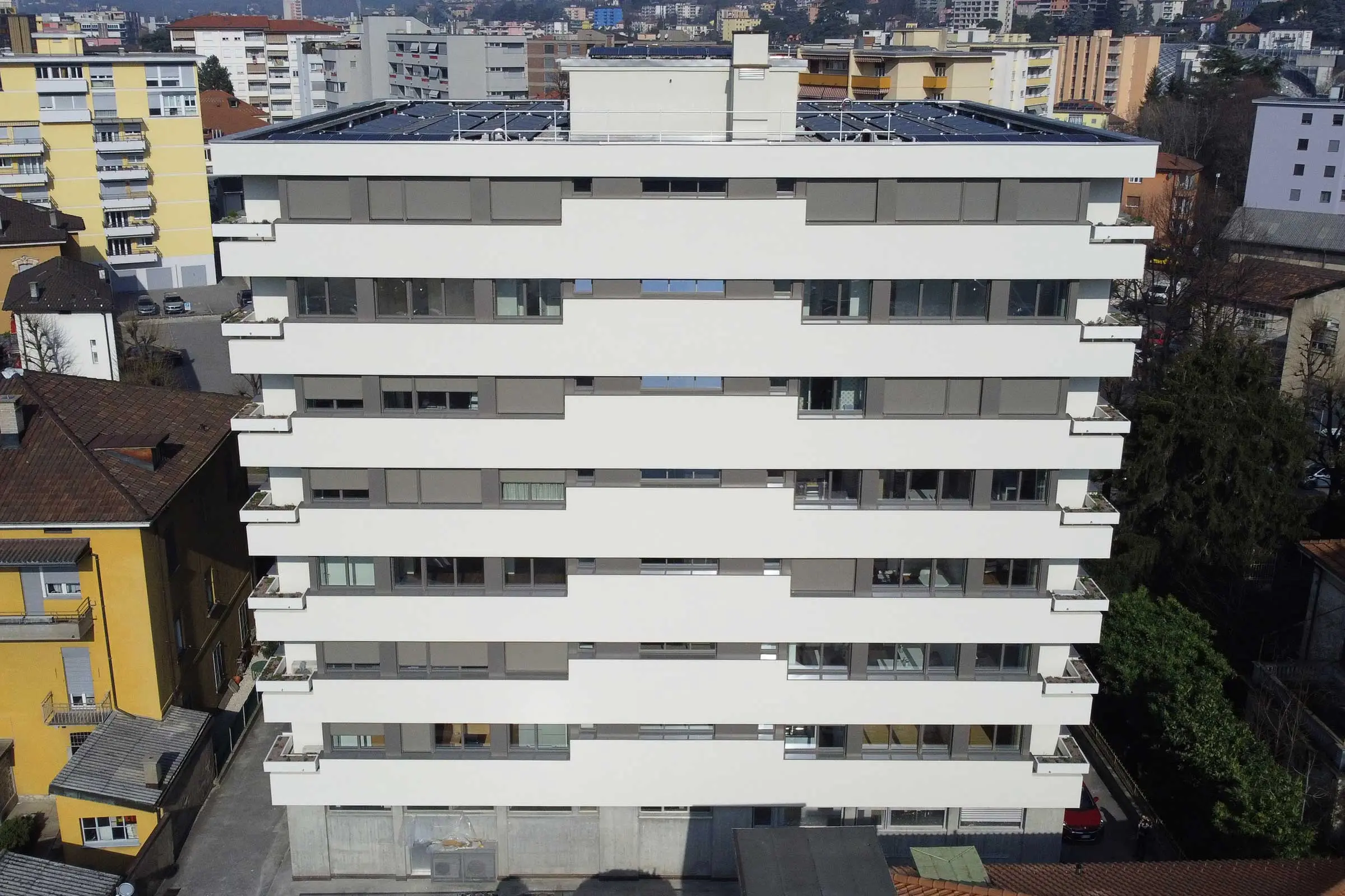 Mehrstöckiges Wohn- und Geschäftshaus mit Balkonen mit eine Putzfassade cremefarben