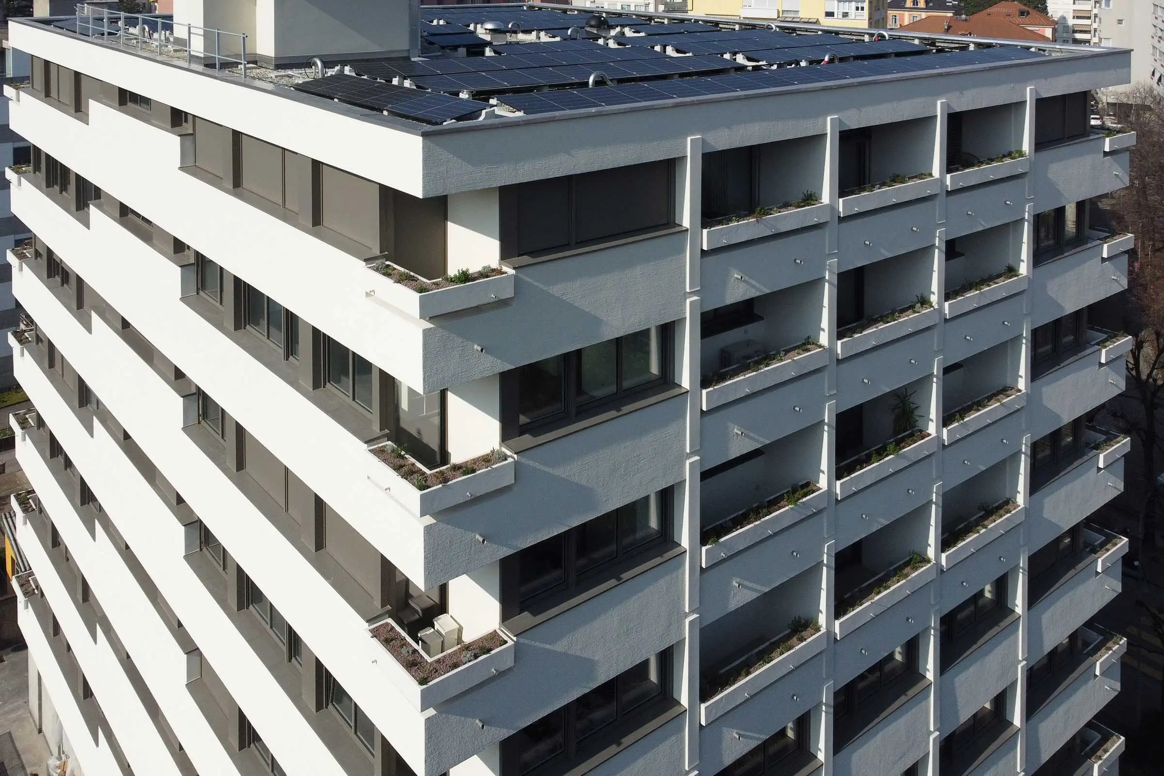 Seitenansicht mehrstöckiges Wohn- und Geschäftshaus mit Balkonen mit eine Putzfassade cremefarben