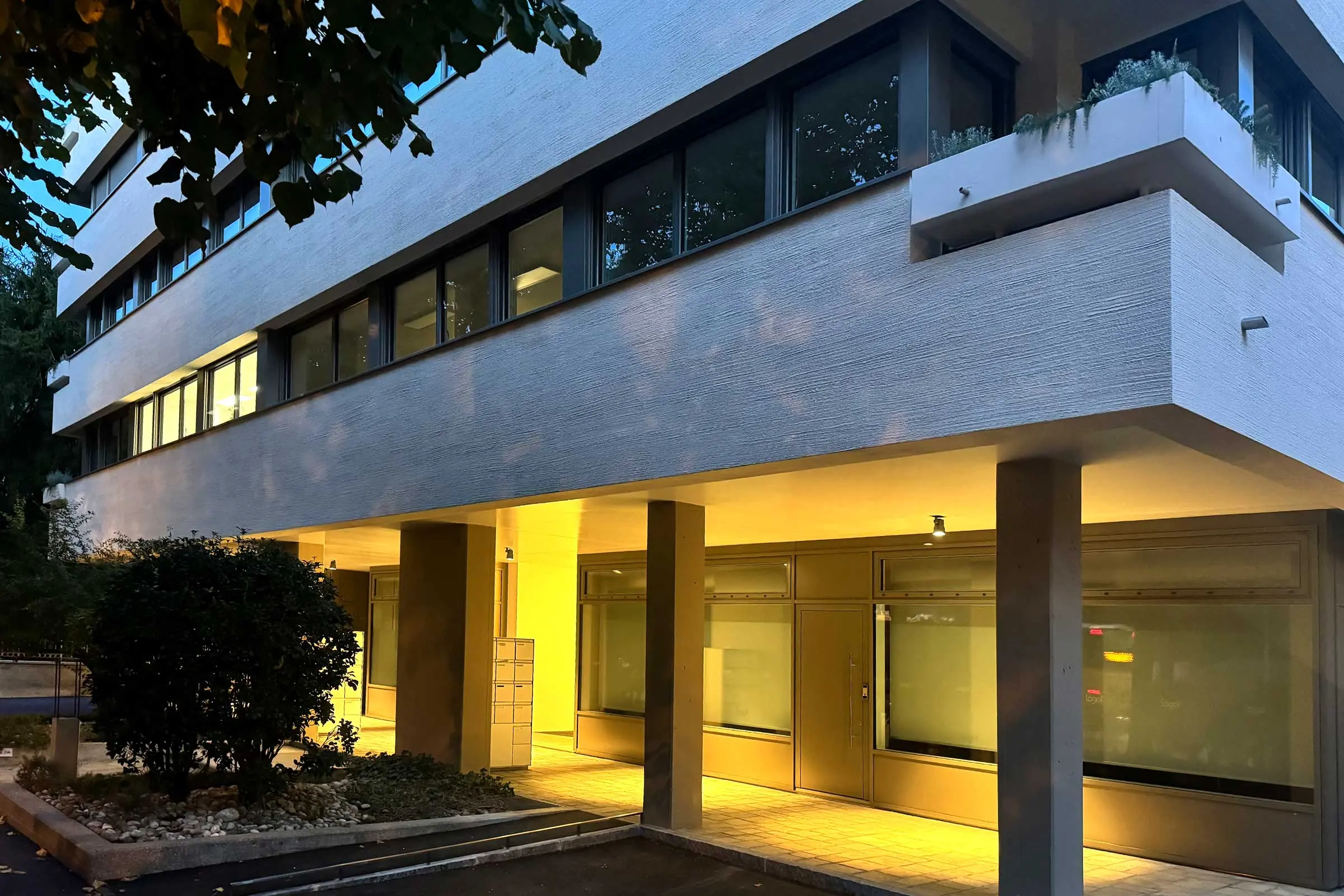 Eingangsbereich eines mehrstöckigen Wohn- und Geschäftshauses mit Beleuchtung
