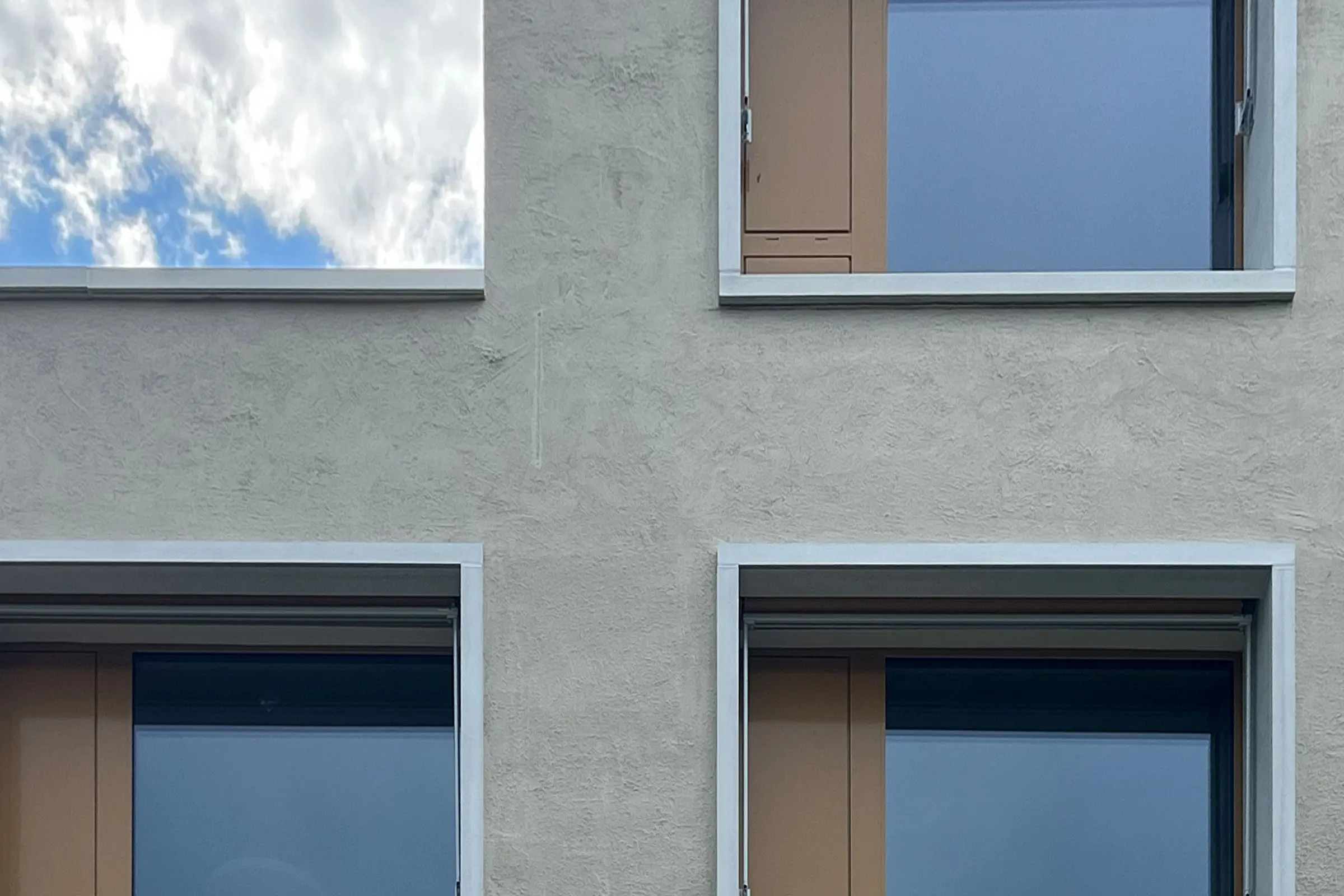 Nahaufnahme beige Fassade mit  4 Fenstern