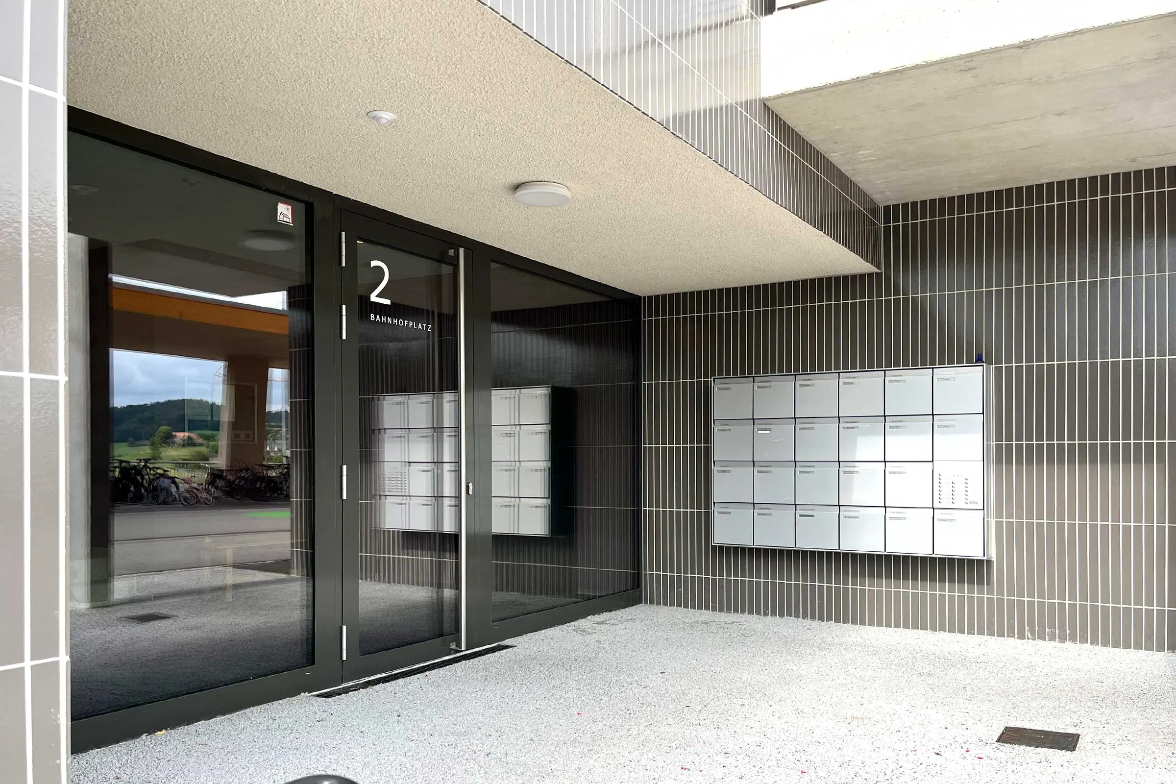 Ingresso del condominio con zoccolo in piastrelle di ceramica scura