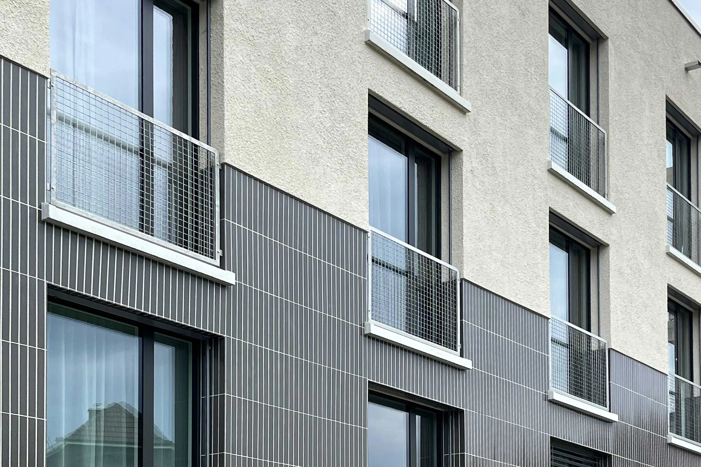 Primo piano della finestra Facciata con intonaco chiaro e piastrelle di ceramica scura