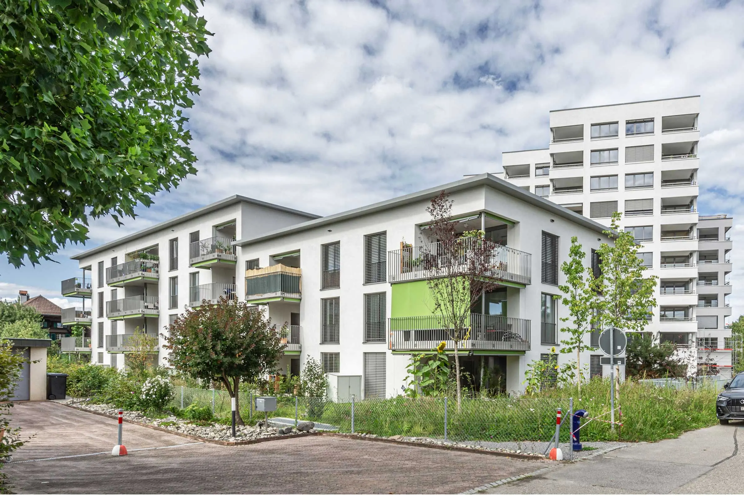 Mehrere Gebäude einer Wohnüberbauung, Umbau und Neubau mit weisser Fassade