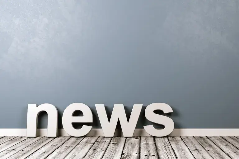 Schriftzug news an eine graue Wand gelehnt