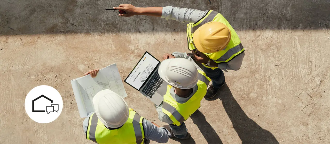  Personen bei einem Gespräch auf der Baustelle