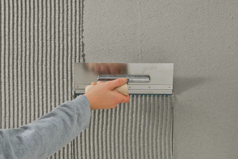 Funktionsspachtel wird mit Kelle auf eine Dämmplatte appliziert