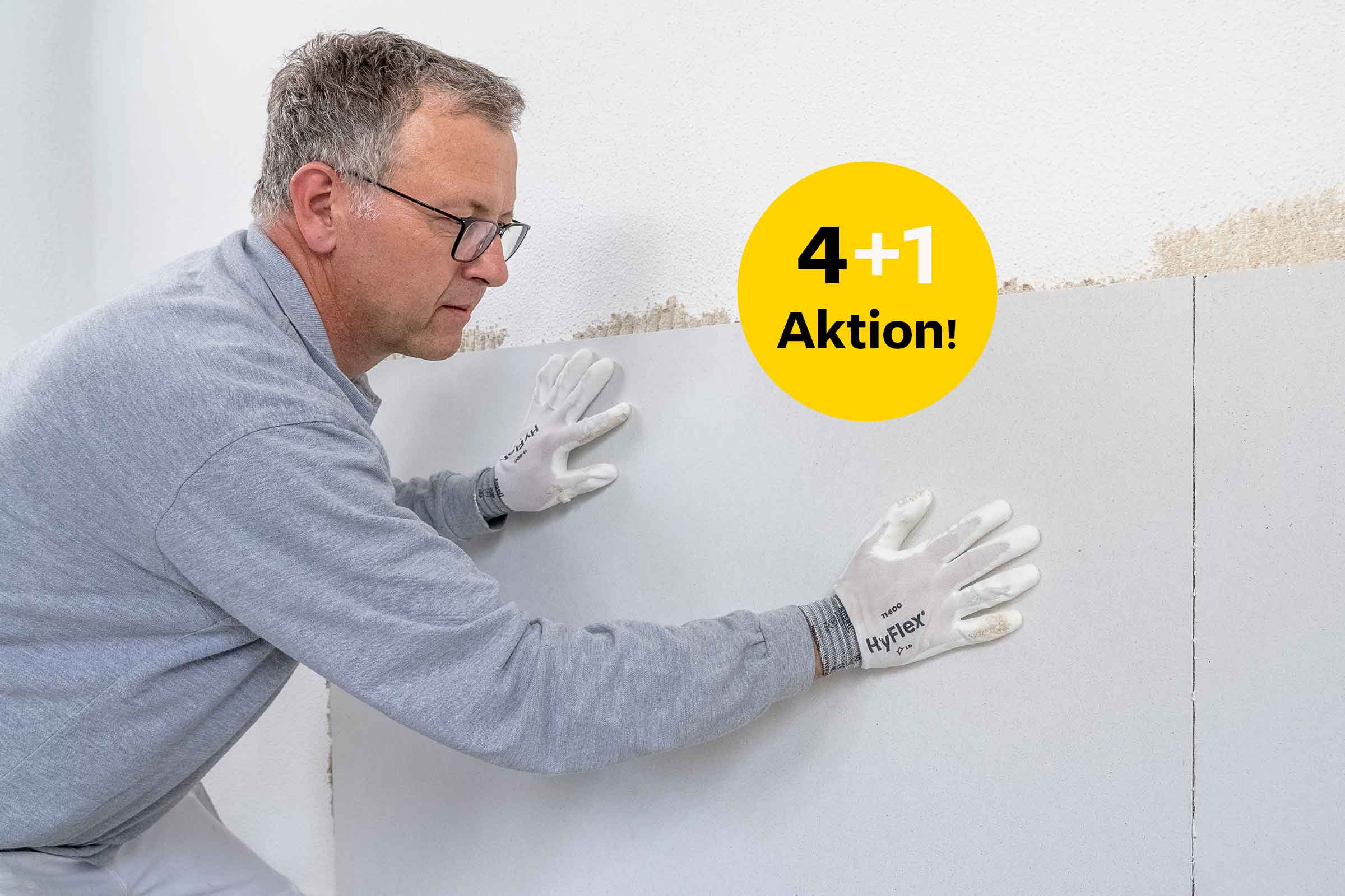 Facharbeiter appliziert Putzträgerplatte an die Wand 