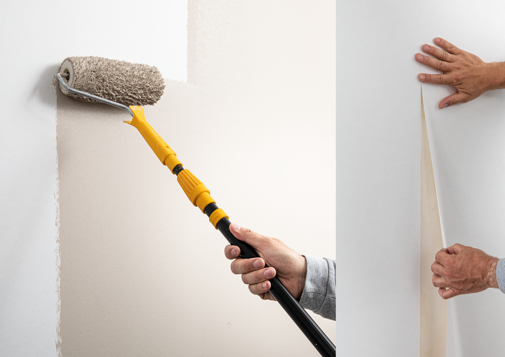 Fachhandwerker schneidet von einer Rolle Cellulosevlies mit dem Cuttermesser ab