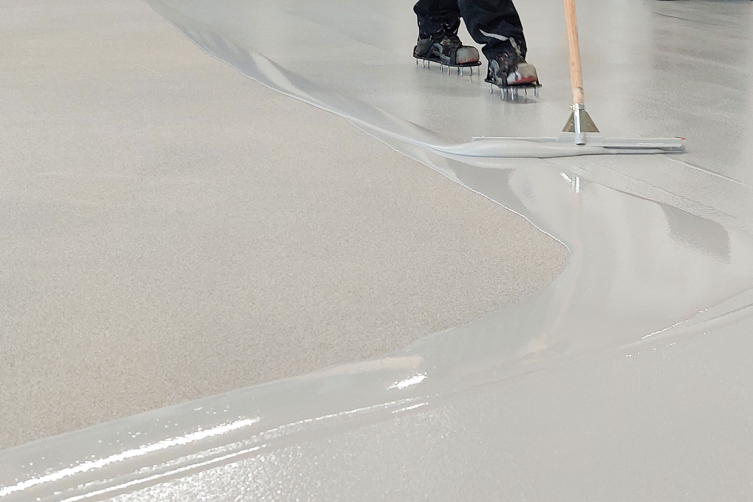 Bodenverlegung mit grauer flüssiger Bodenbeschichtung