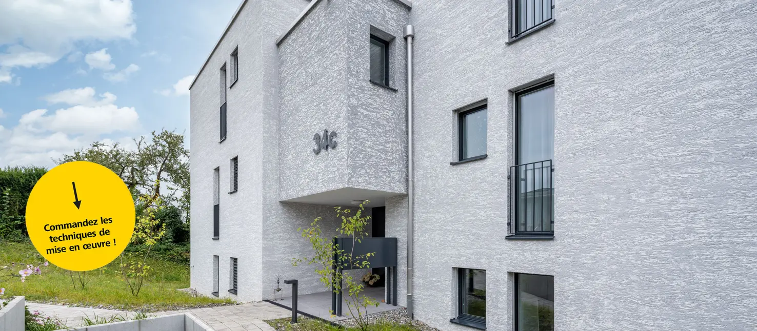 Immeuble collectif avec façade crépie en StoSignature clair plus bouton de commande jaune